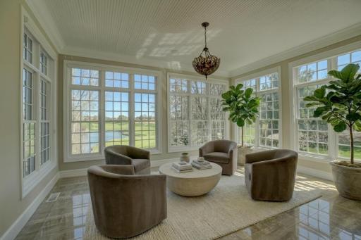 The sun-filled sitting area just off the kitchen captures sweeping views of the course. (virtually staged)