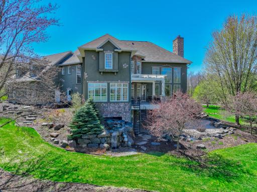 Surrounding the patio, a recirculating stream, pond, and additional waterfall feature introduce a dynamic water element that elevates the experience.