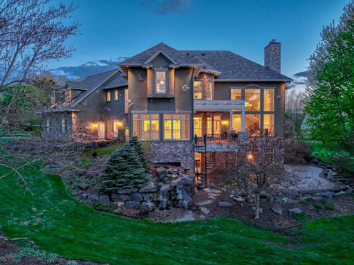The outdoor setting is truly one-of-a-kind, featuring an expansive freeform patio designed for both comfort and connection to the surroundings, enhanced by a Phantom screen enclosure at the touch of a button.