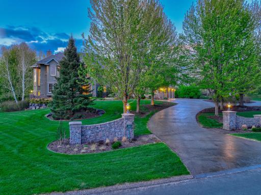 A tree-lined drive and beautifully manicured grounds create a striking first impression, leading to a home where craftsmanship and design are evident at every turn.