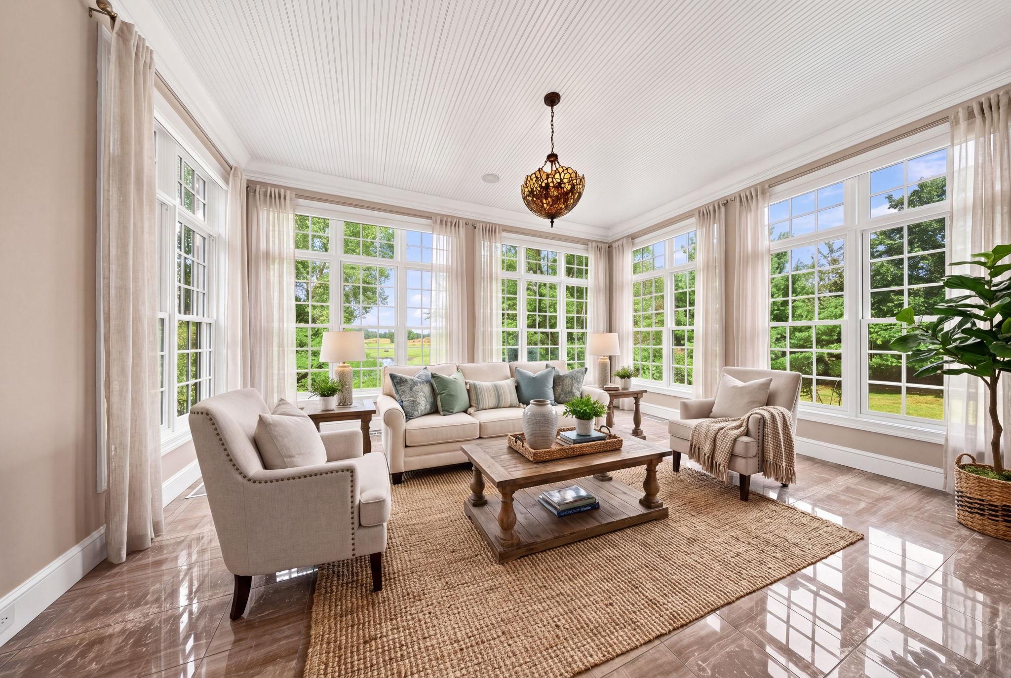 The sun-filled sitting area just off the kitchen captures sweeping views of the course. (virtually staged)