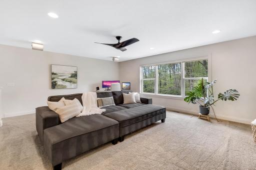 Upstairs loft with ceiling fan and large windows