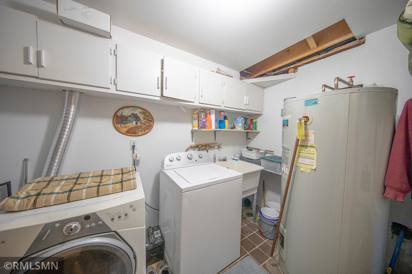 Ample laundry room with electric hot water heater and added under stair storage