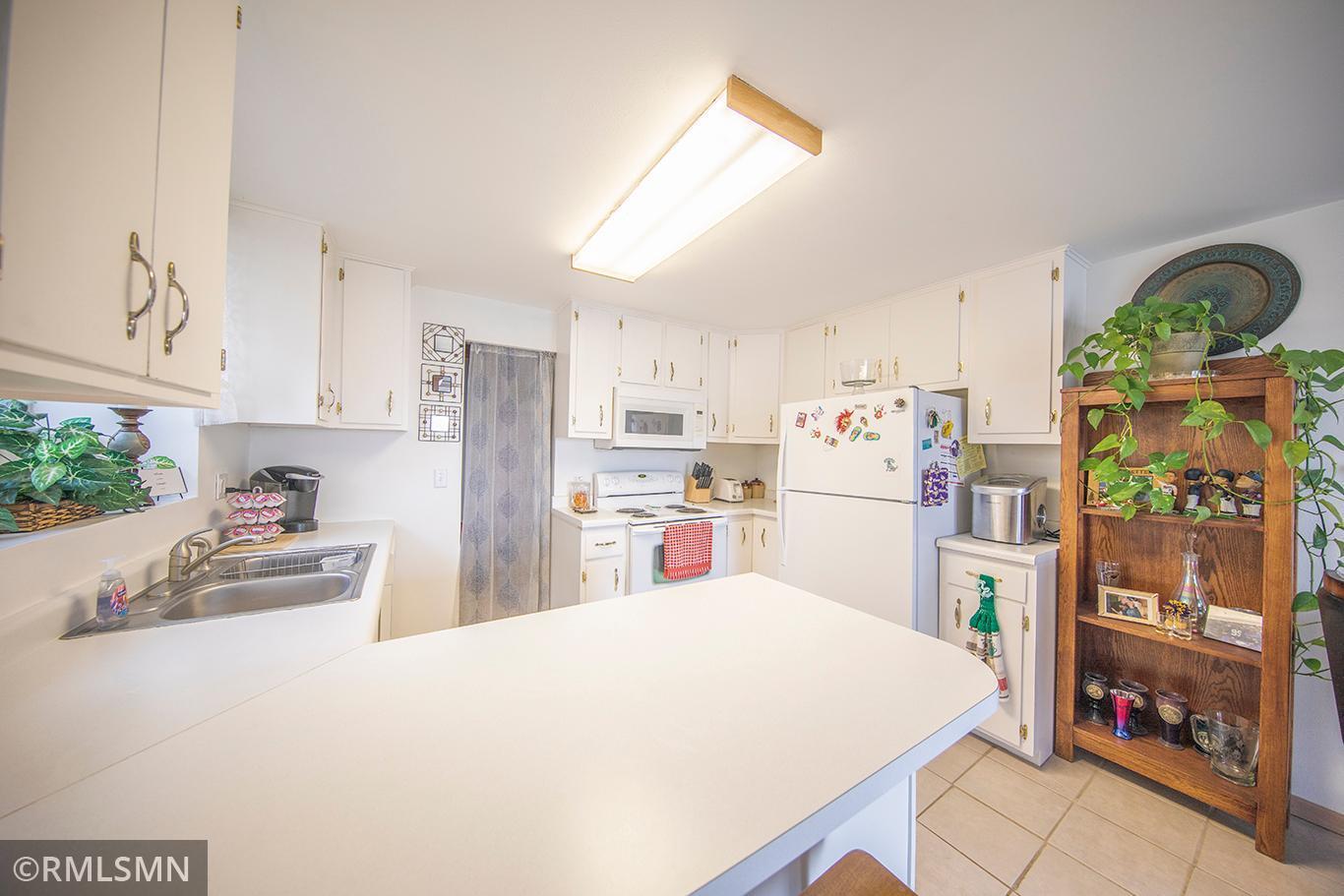 Lovely bright kitchen with light streaming in from the window and patio doors.