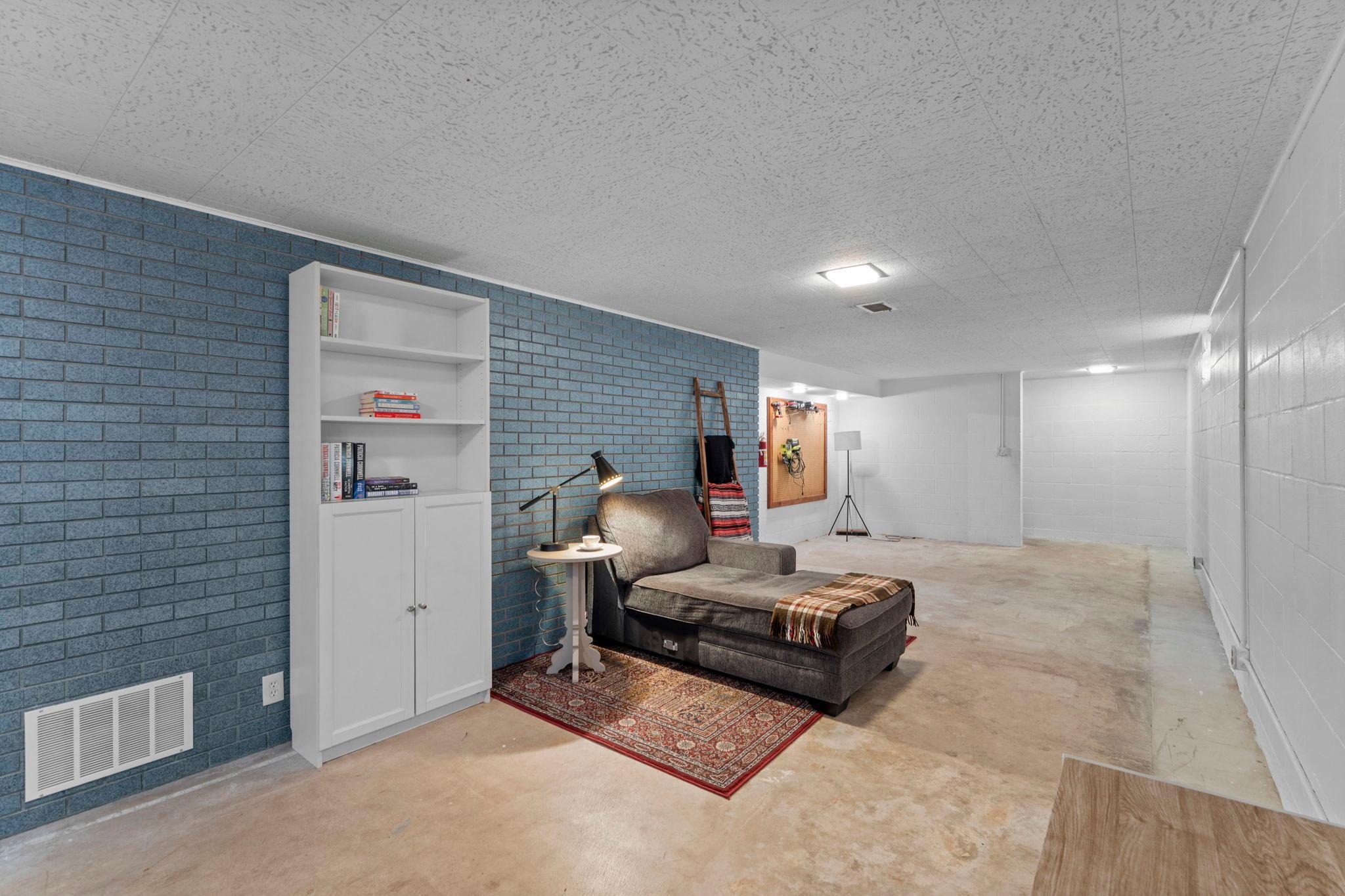 It features a spacious family room anchored by a stunning blue brick statement wall.