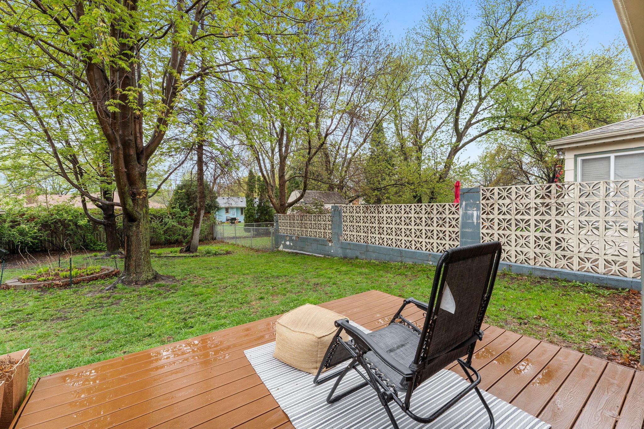 Outside, the home truly shines. The large, private backyard is fully fenced (2022) and enhanced with a partial stone wall that adds both privacy and character.