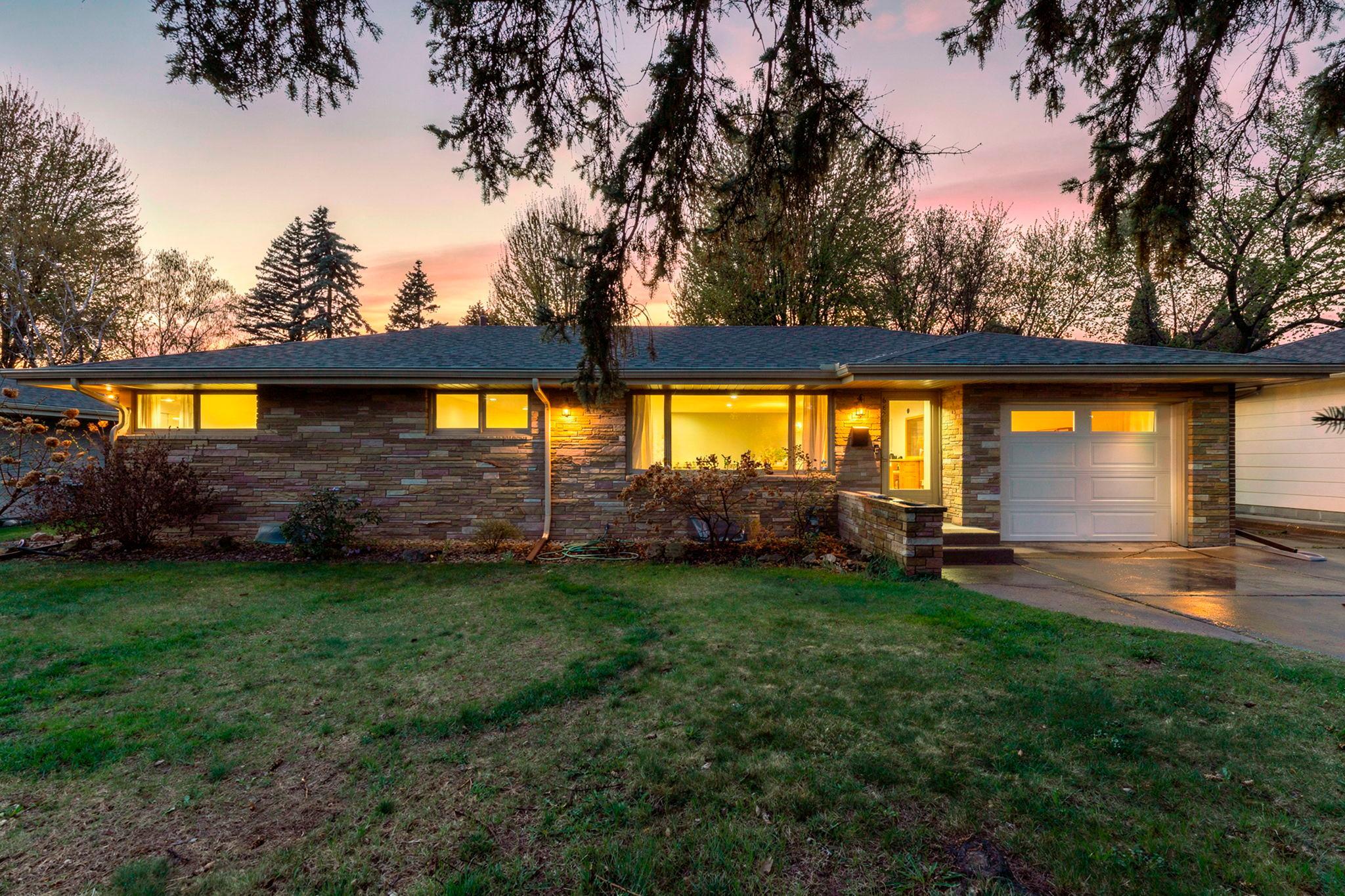 The stone and brick exterior elevate the home’s curb appeal, while the attached one-car garage and wide driveway provide plenty of off-street parking.