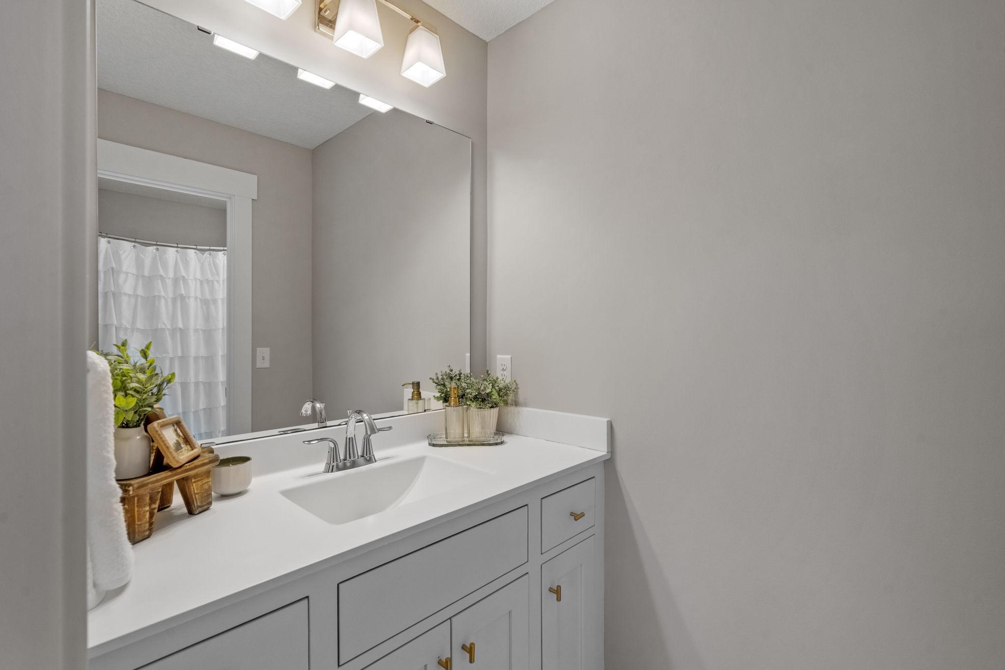 Jack-and-Jill style bathroom connecting bedrooms #3 and #4, featuring separate vanities.