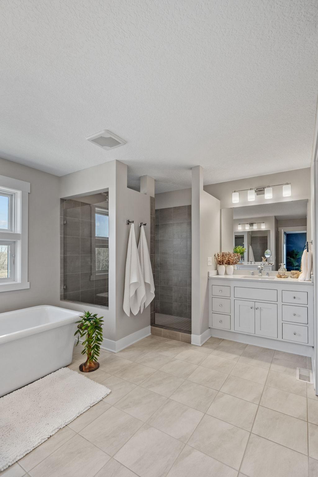 Crisp, neutral finishes paired with separate vanities create a calming, spa-inspired environment.