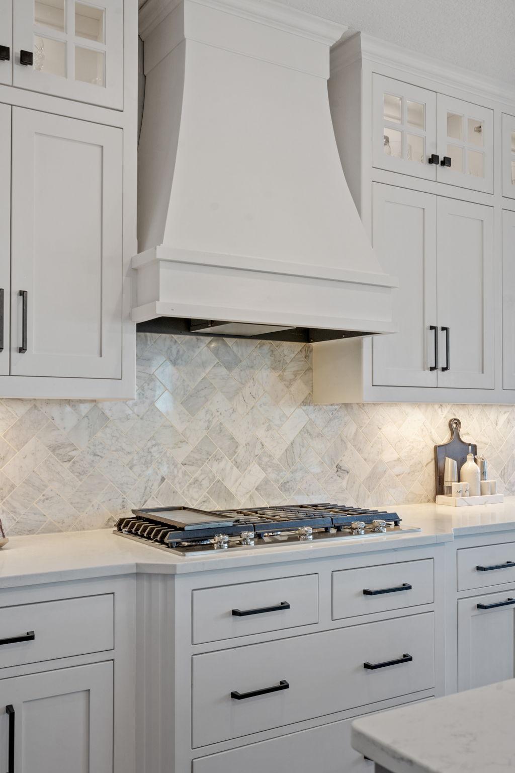 Statement range hood and tile backsplash create a stunning focal point.