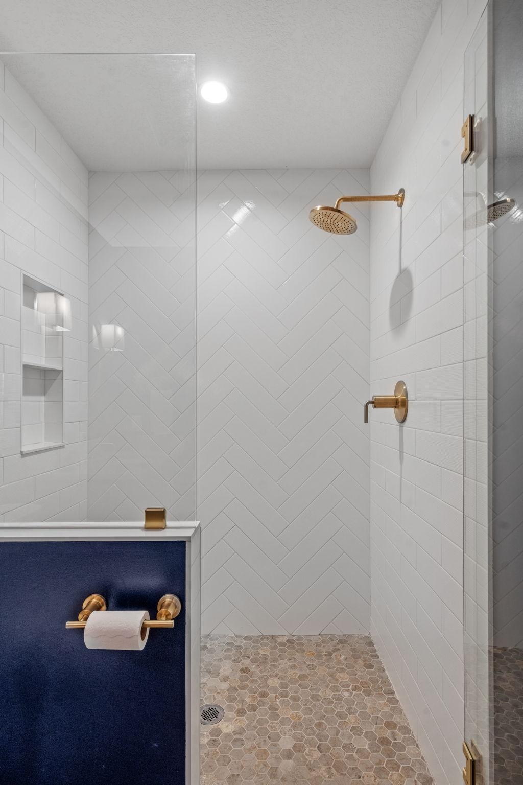 Rich, dark tones set the vibe while the crisp white tile and glass shower keep it fresh, clean, and anything but basement basic.