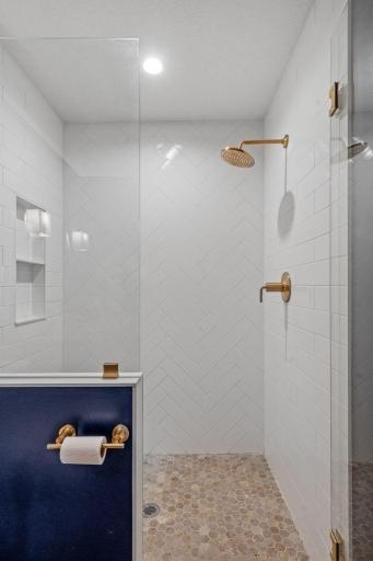 Rich, dark tones set the vibe while the crisp white tile and glass shower keep it fresh, clean, and anything but basement basic.