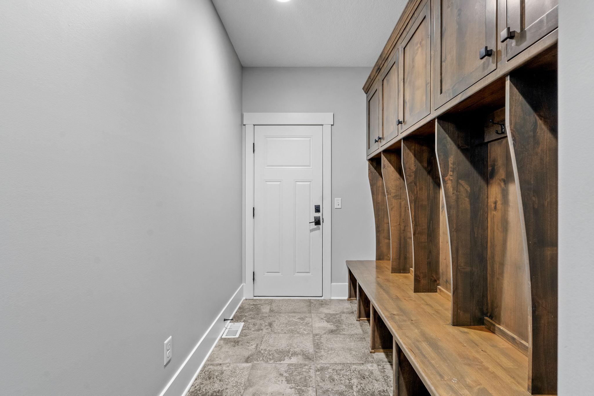 This thoughtfully designed mudroom features built-in lockers off the garage entry, creating a seamless drop zone. Adjacent is an impressive 14x8 walk-in closet, offering exceptional storage to keep everything organized. and out of sight.
