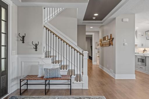 Thoughtfully designed entry with clean lines, warm wood accents, and a staircase that blends classic detail with modern style.