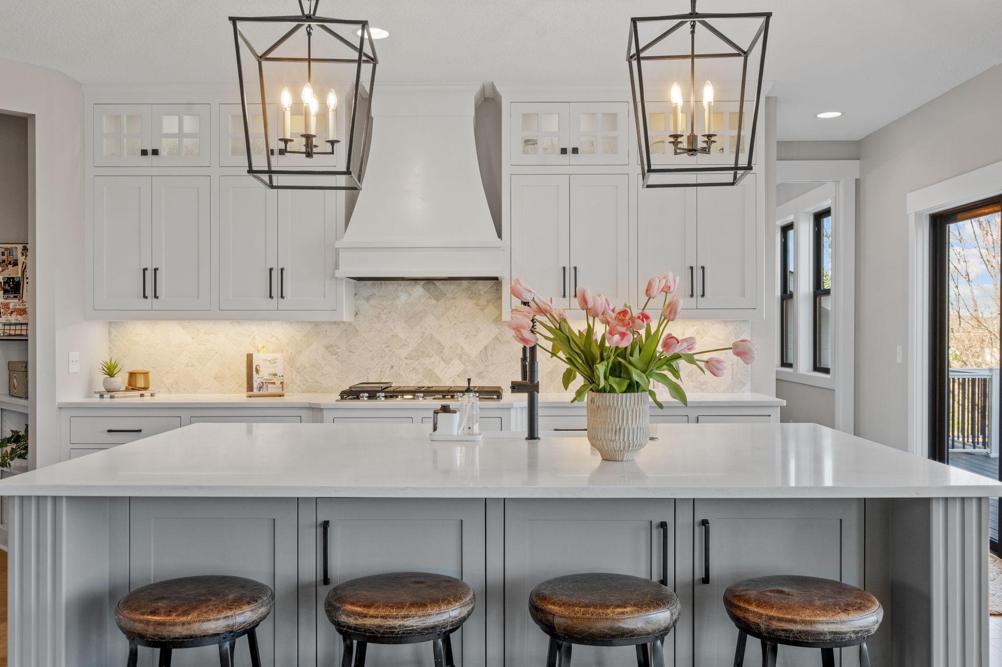 Stunning chef’s kitchen with a large center island, quartz countertops, custom cabinetry, and designer lighting, perfect for both everyday living and entertaining.