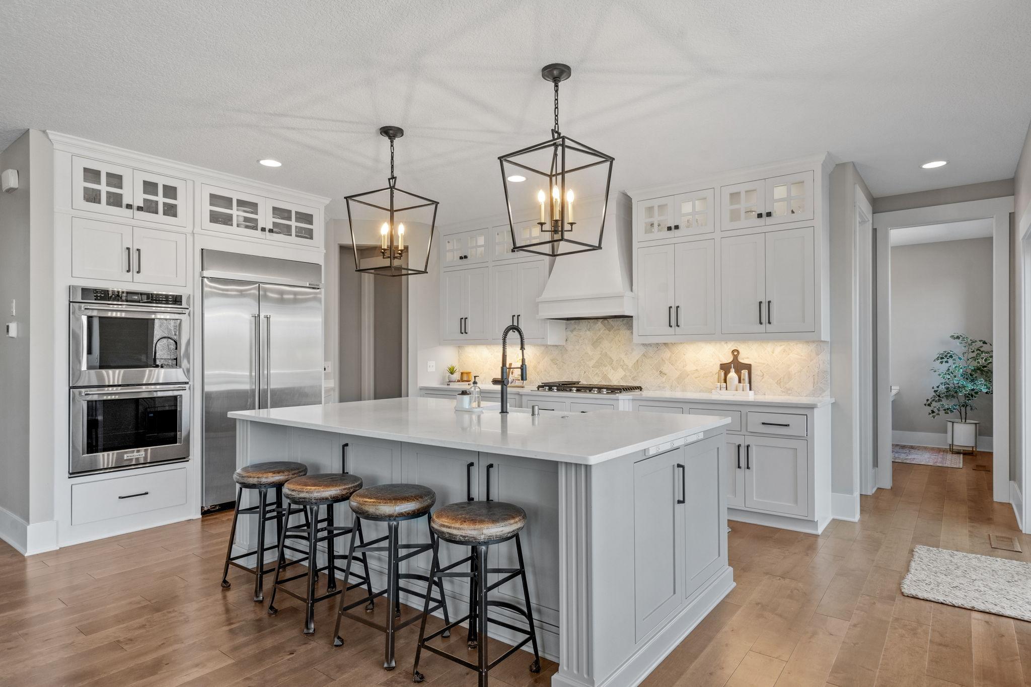 Custom cabinetry with glass-front uppers offers both style and functional storage.
