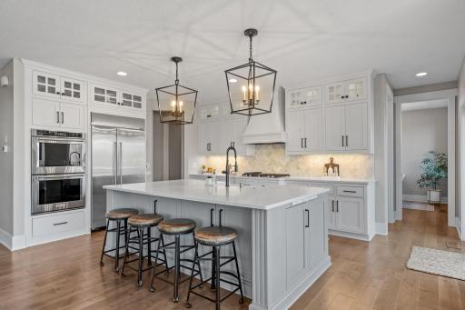 Custom cabinetry with glass-front uppers offers both style and functional storage.
