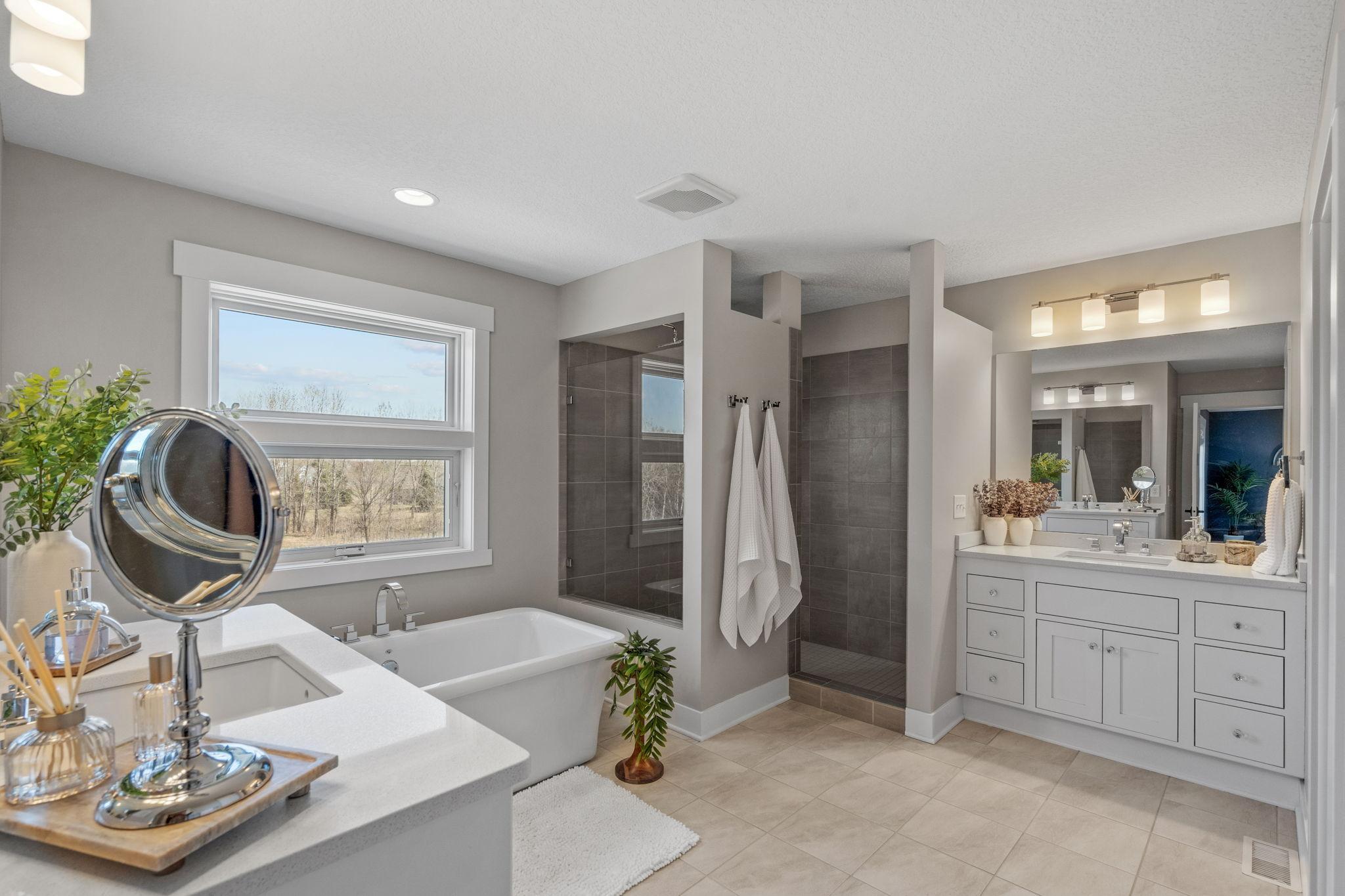 Bright, natural light pouring in through oversized windows, giving the entire primary bathroom suite an airy, refreshing feel.