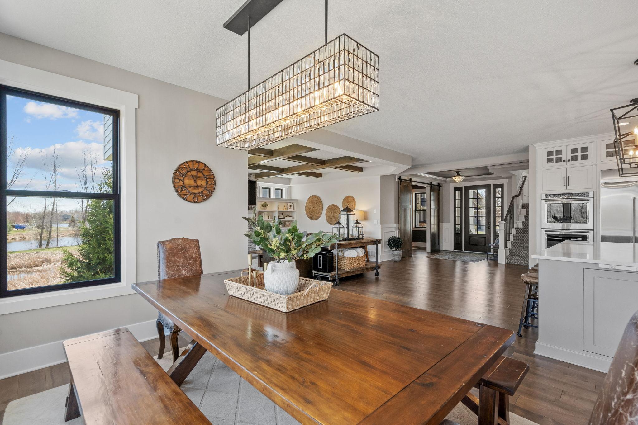 Statement linear chandelier anchors the dining space with a modern, elevated feel.