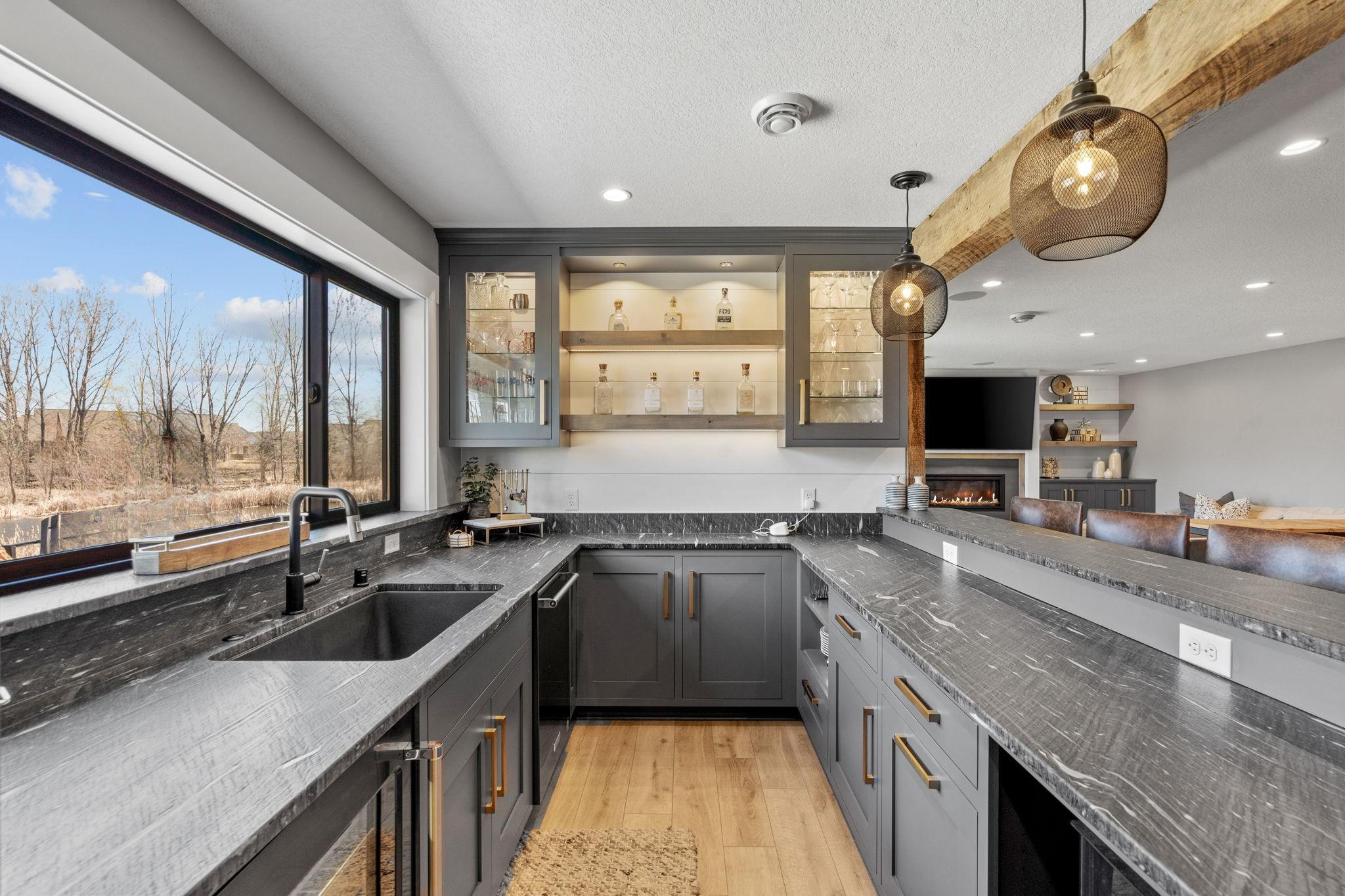 Thoughtfully designed with custom cabinetry, statement lighting, and open shelving to showcase your favorite spirits and glassware.