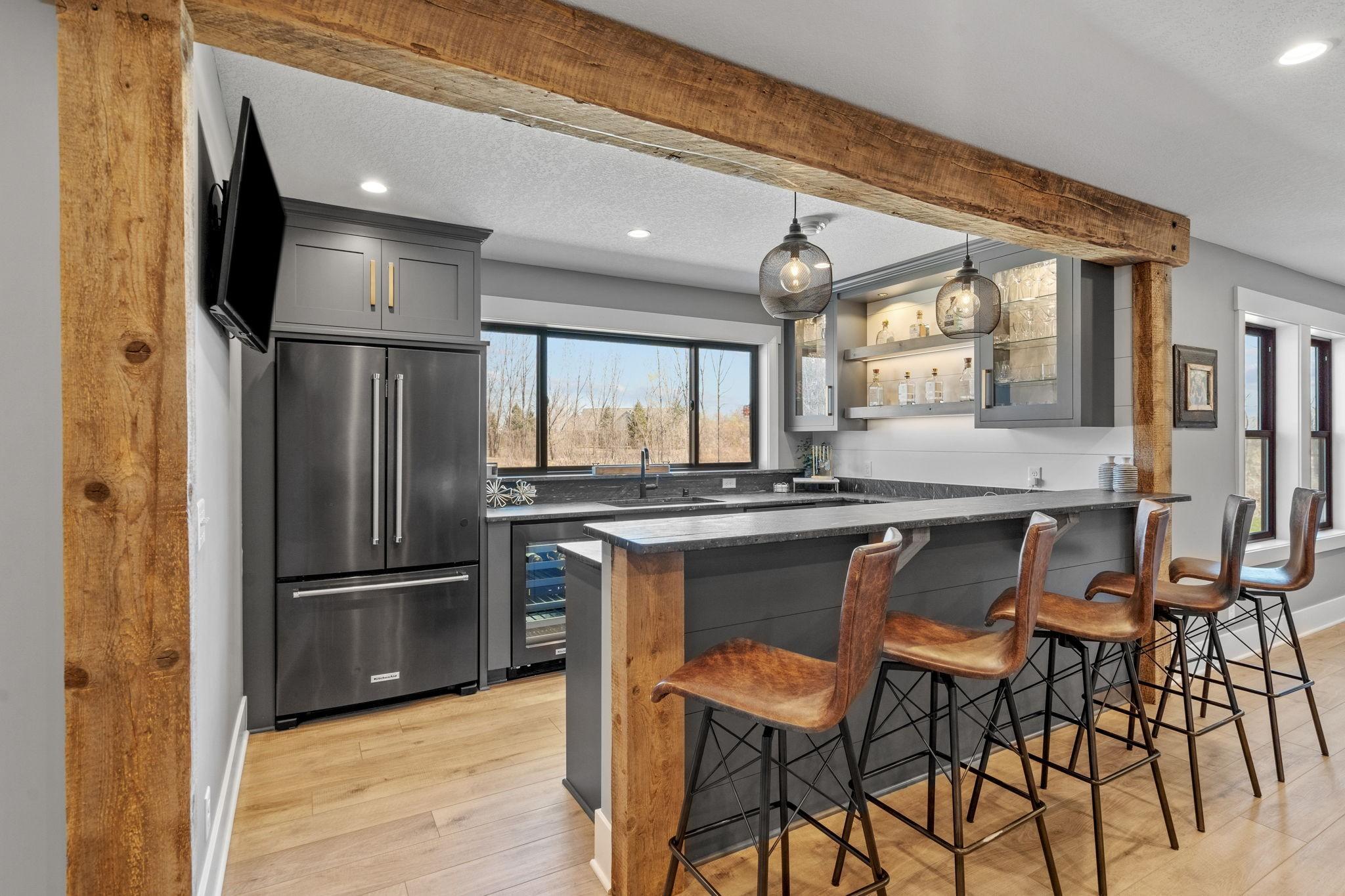 Entertain effortlessly with a full bar setup complete with sink, fridge/freezer, beverage fridge, and plenty of prep space for hosting game days or weekend get-togethers.