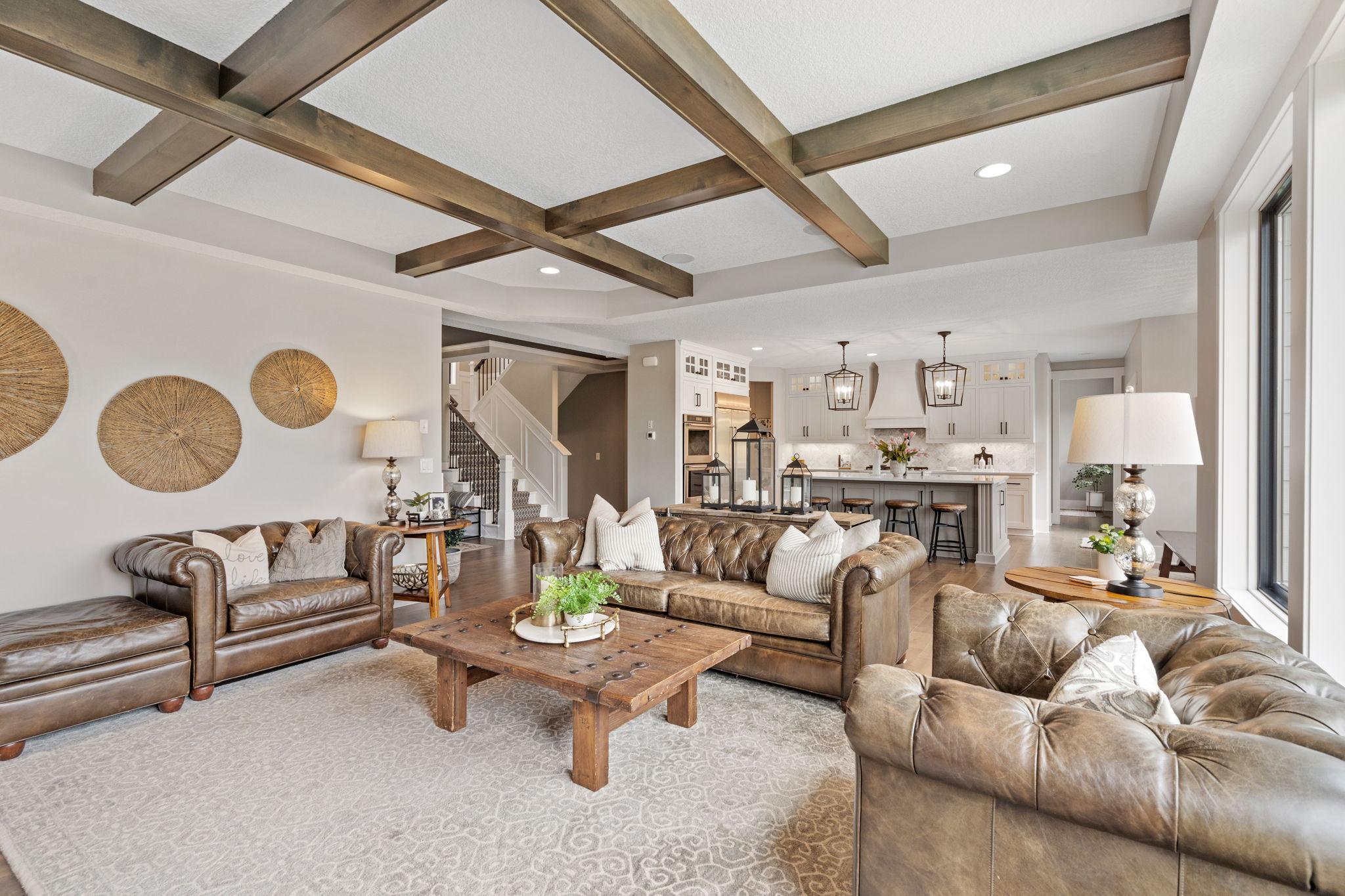 Custom details at every turn. From the coffered ceiling beams to the designer kitchen beyond, this space was built to impress without sacrificing comfort.