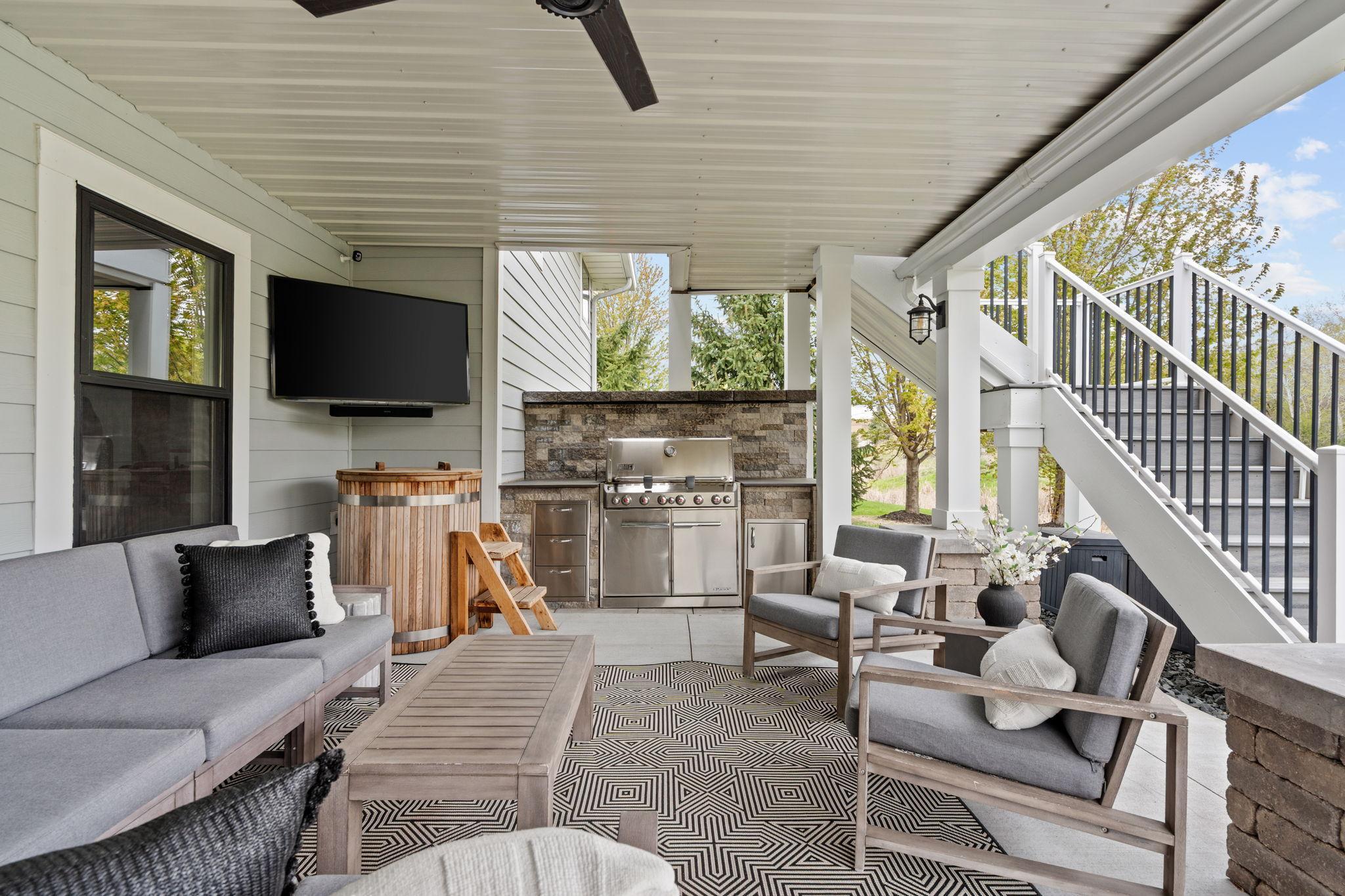 Covered patio perfection - cozy seating, a built-in grill, and space to relax or entertain no matter the season.