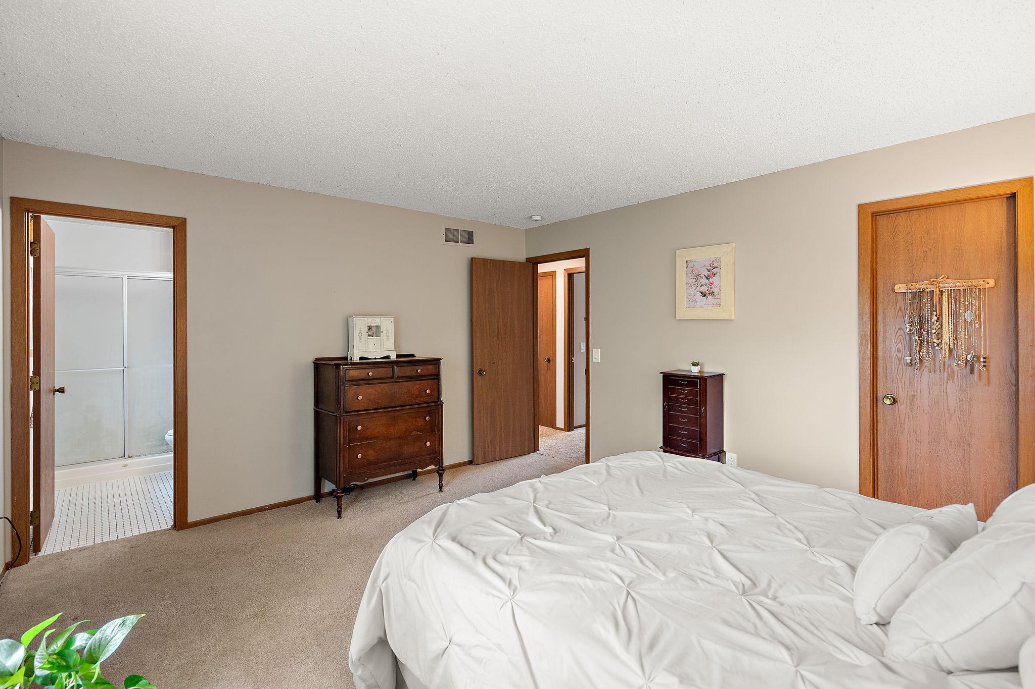 The primary bedroom has en suite bathroom visible through the open door on the right.