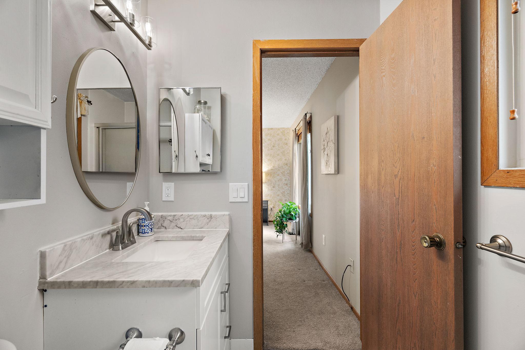 A view from the primary en suite bathroom into the primary bedroom