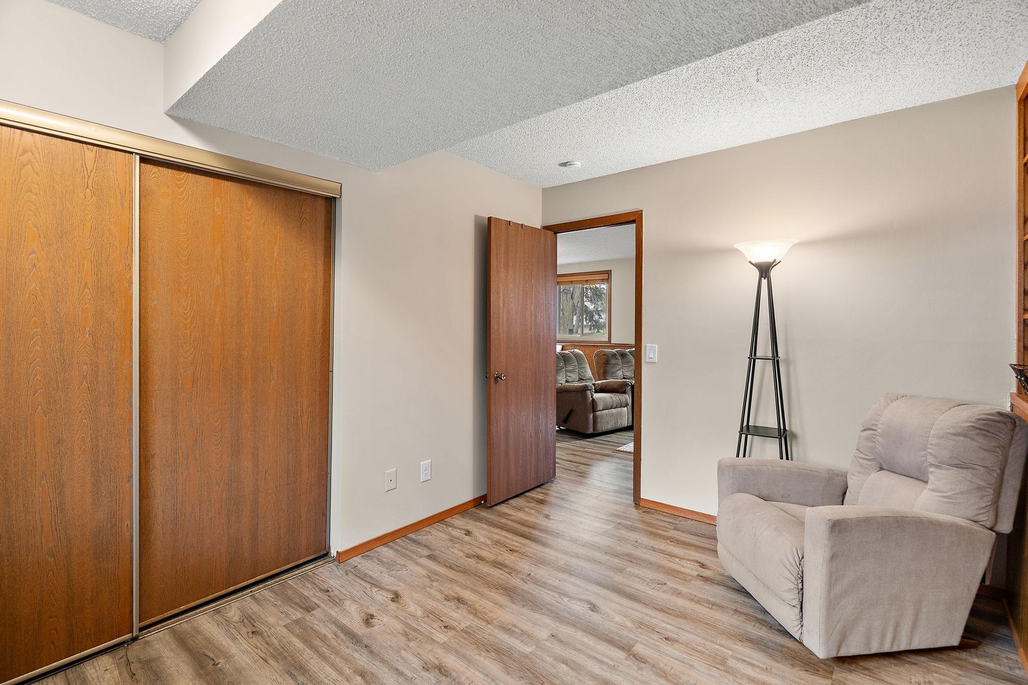 A view from the lower level fourth bedroom with a glimpse of the recreation room through the open door.