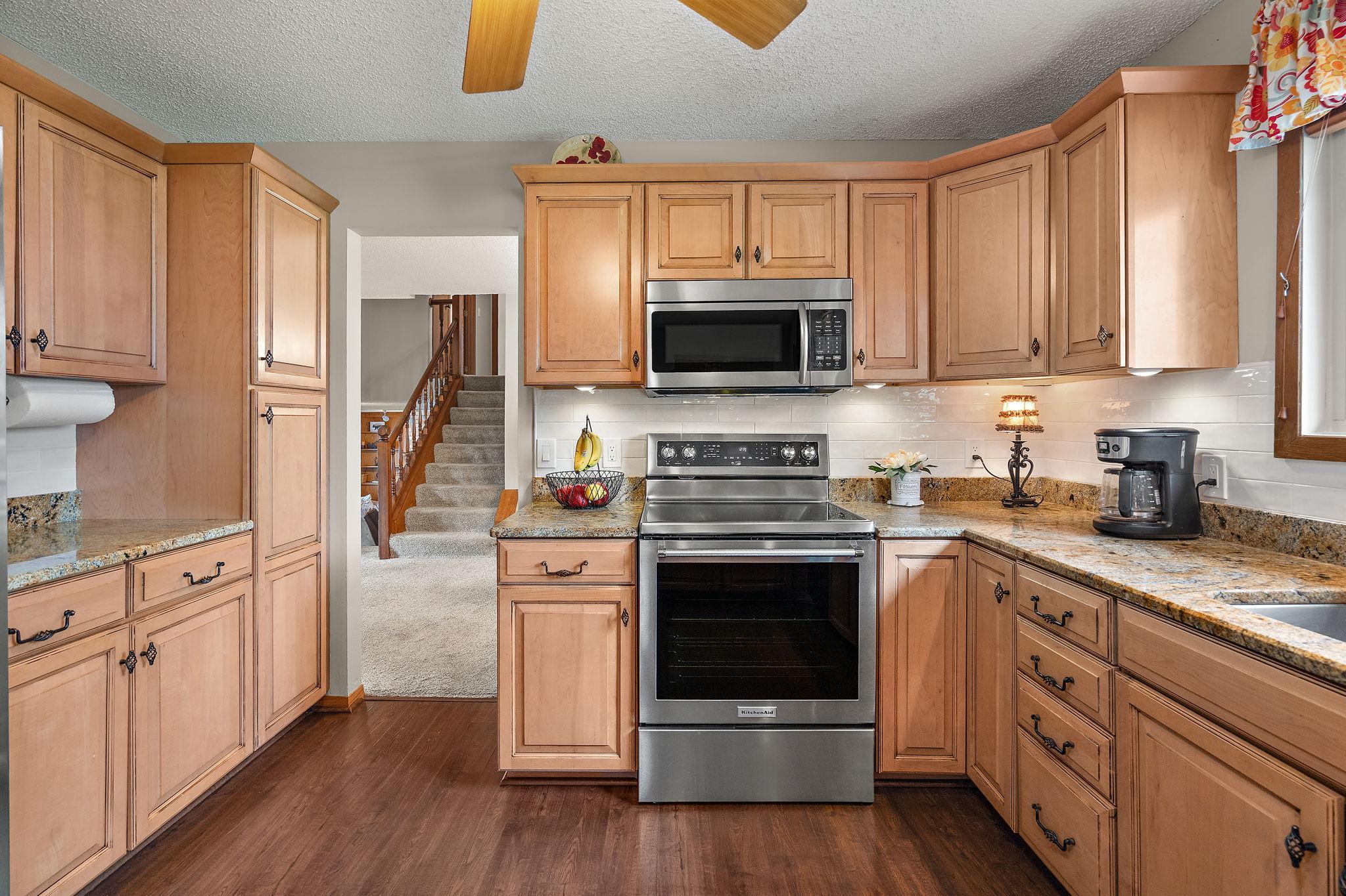 The kitchen has ample storage space with many cabinets and counter top room for meal prep.