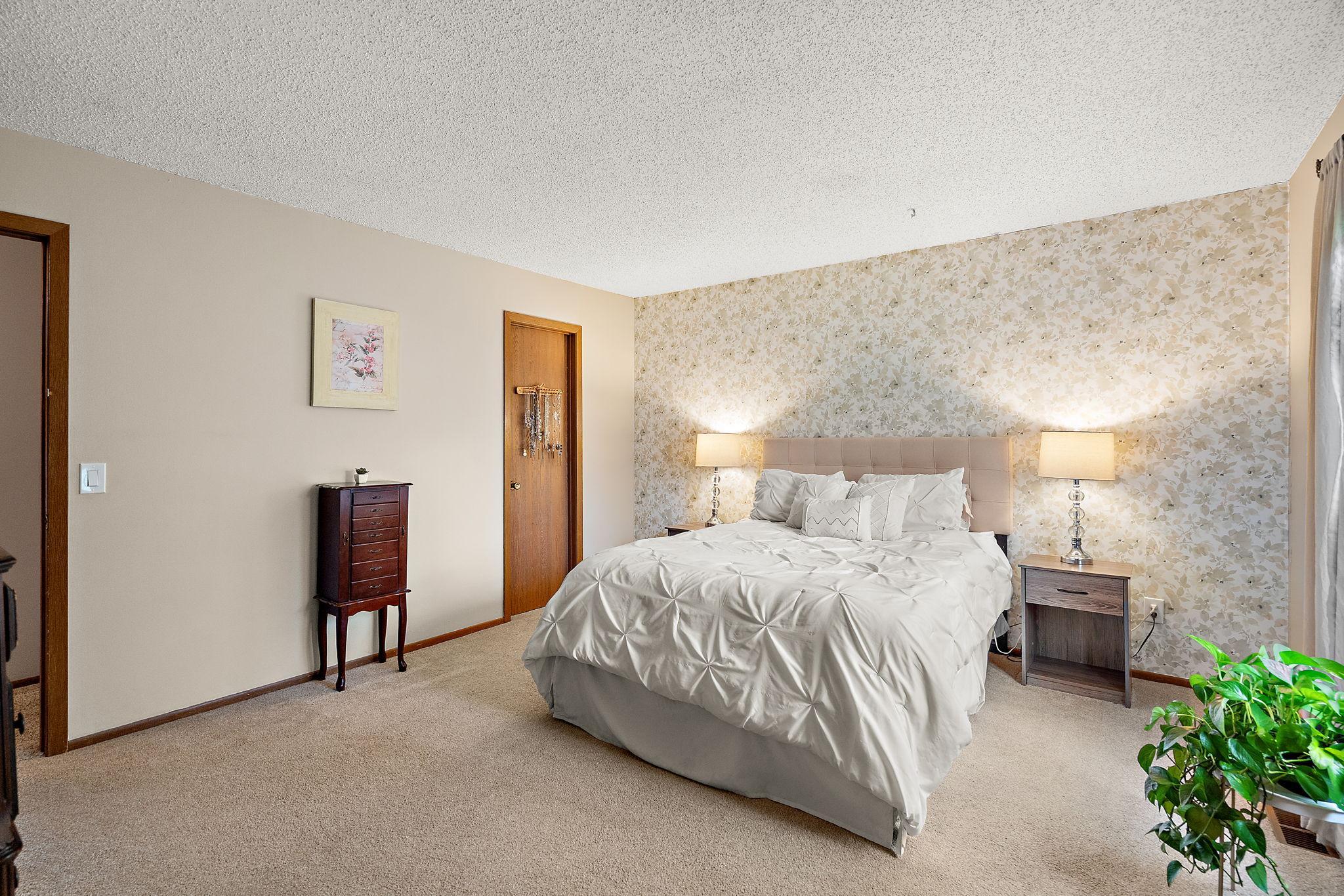 The upper level primary bedroom with walk-in closet through the closed door beyond.