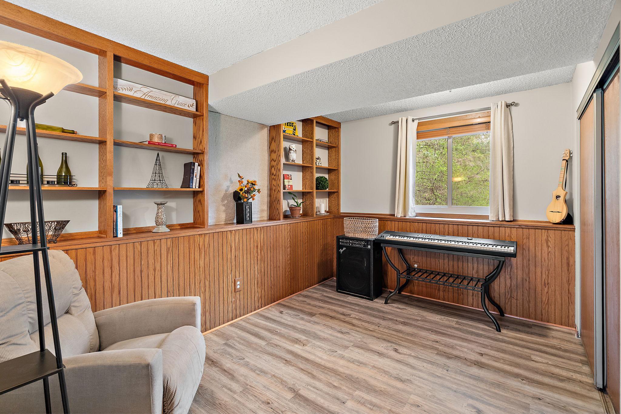 The fourth bedroom is located in the lower level and has a window view and lovely hardwood flooring with a large closet, visible on the right.