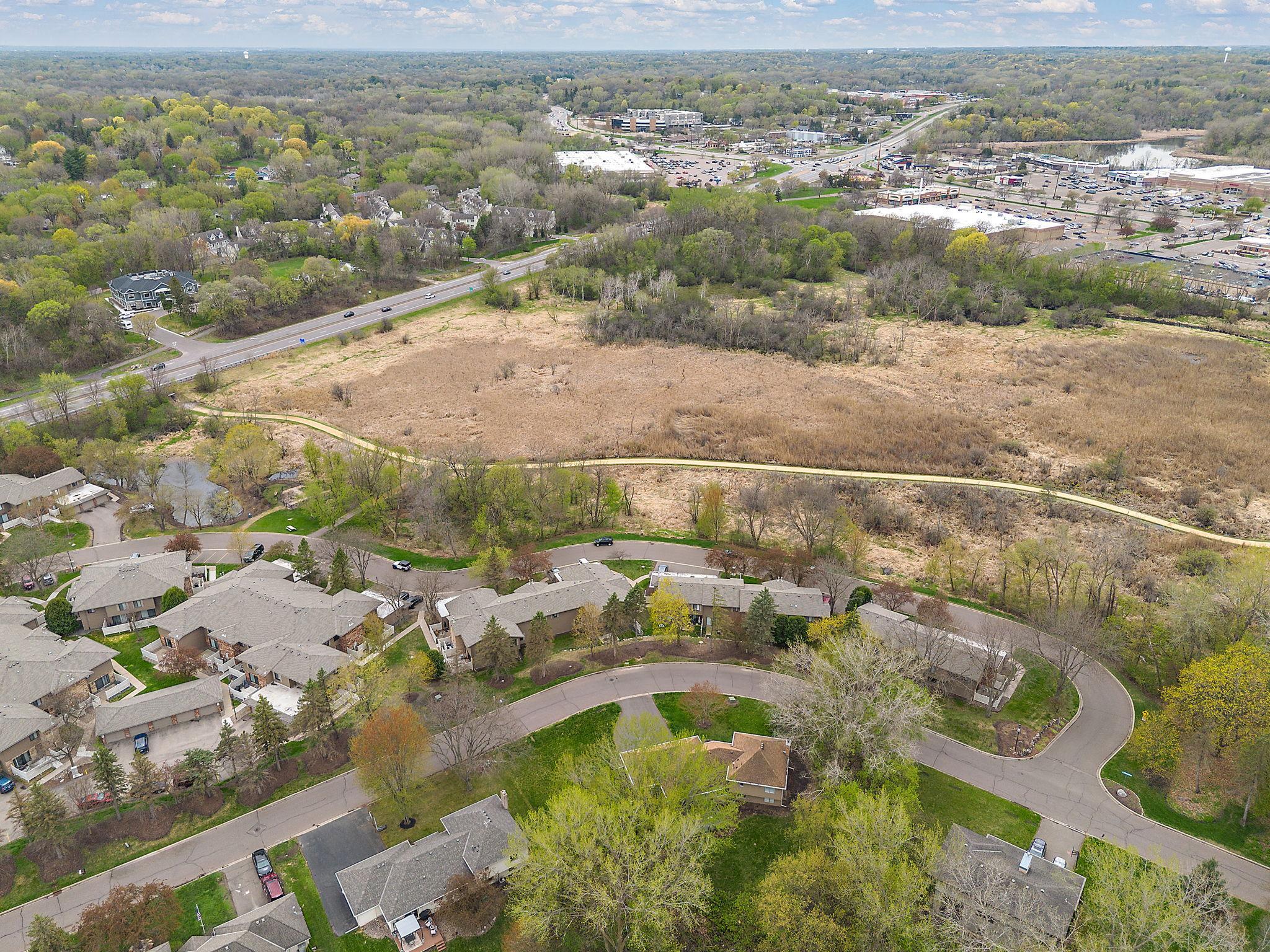 An aerial view of the surrounding neighborhood with Hwy 7 and junction County Rd 101 beyond for convenient access to all the amenities local to Minnetonka.