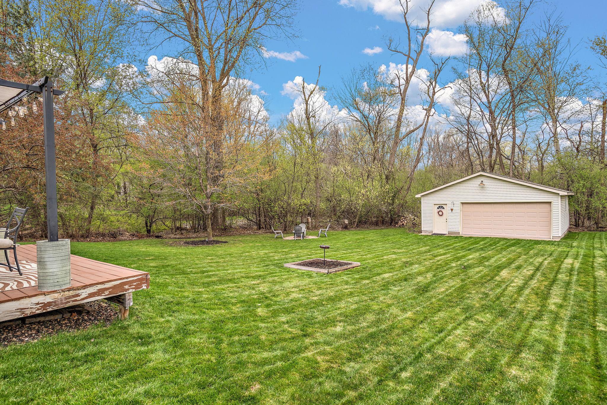 The backyard is spacious, well cared for and features a fire pit for evening gatherings, a raised deck and a large heated garage for additional hobby or storage space. The yard is surrounded by mature trees for a peaceful setting.