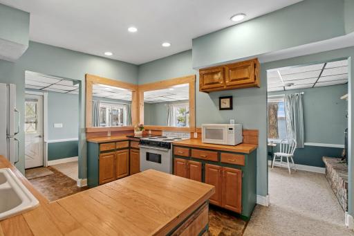 The kitchen at a lake home does real work, and this one is built for it. Warm wood cabinetry, generous counter space, and a pass-through that keeps you connected to every room and every conversation.