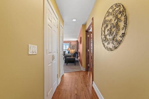 Hardwood underfoot, built-in storage on the left, and the warm glow of the living room and lake just ahead.