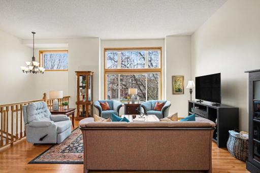 Two story ceiling in the living room has loads of light from the triple window with a transom above.