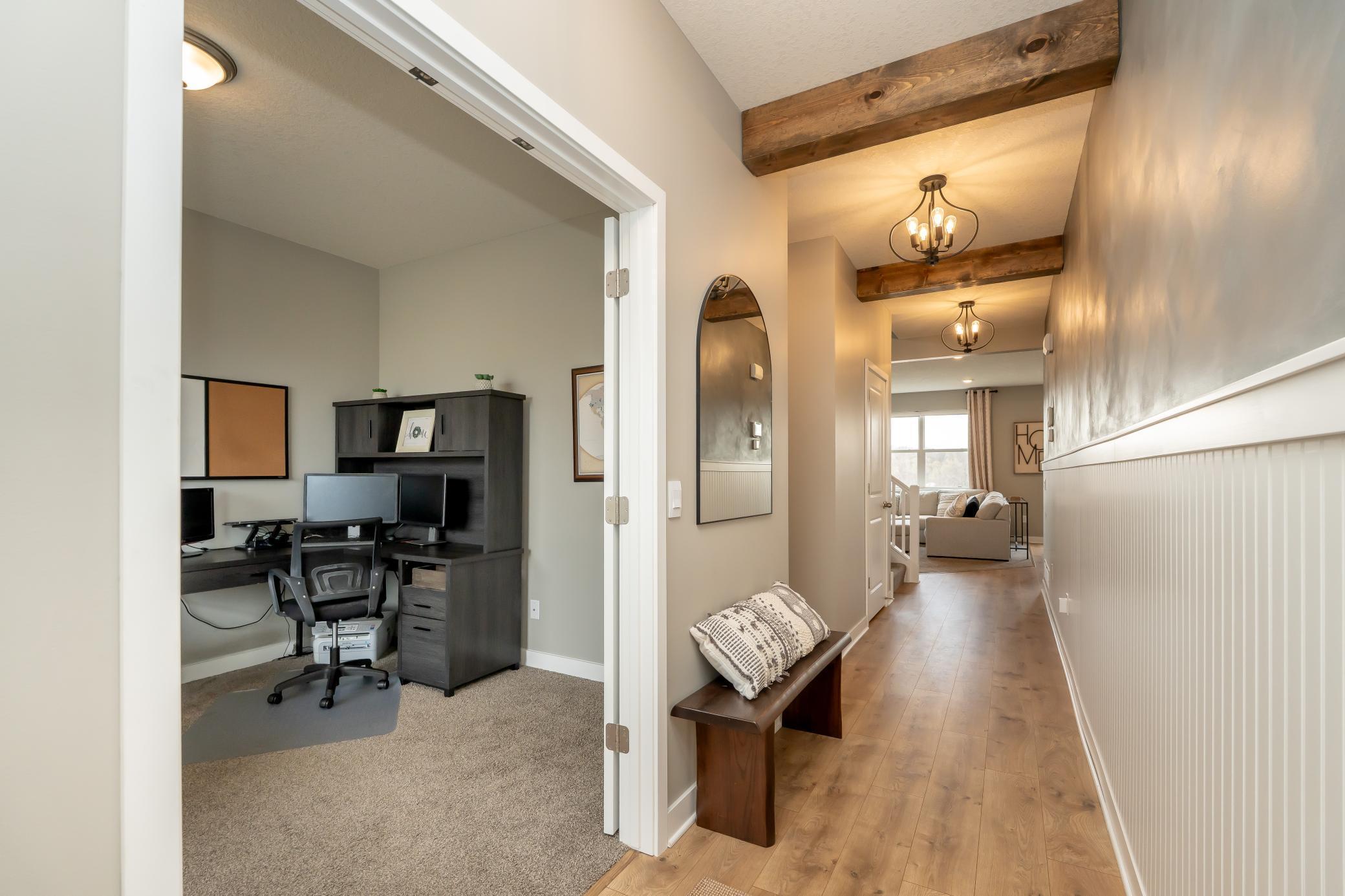 View from the front door into your office or front main level flex room and main flooring living space. Check out those beams