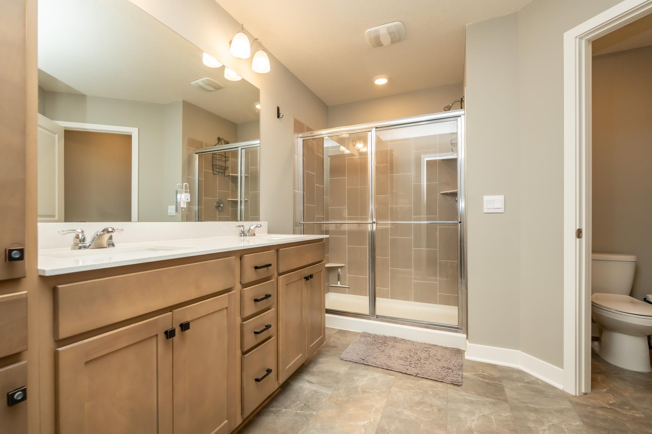 Primary ensuite with dual sinks, shower, toilet room and access to your 2nd closet (next photo)