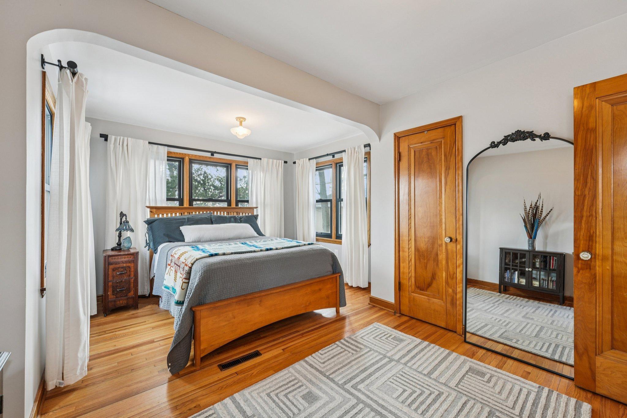 Comfortable main level bedroom with hardwood floors and generous natural light.
