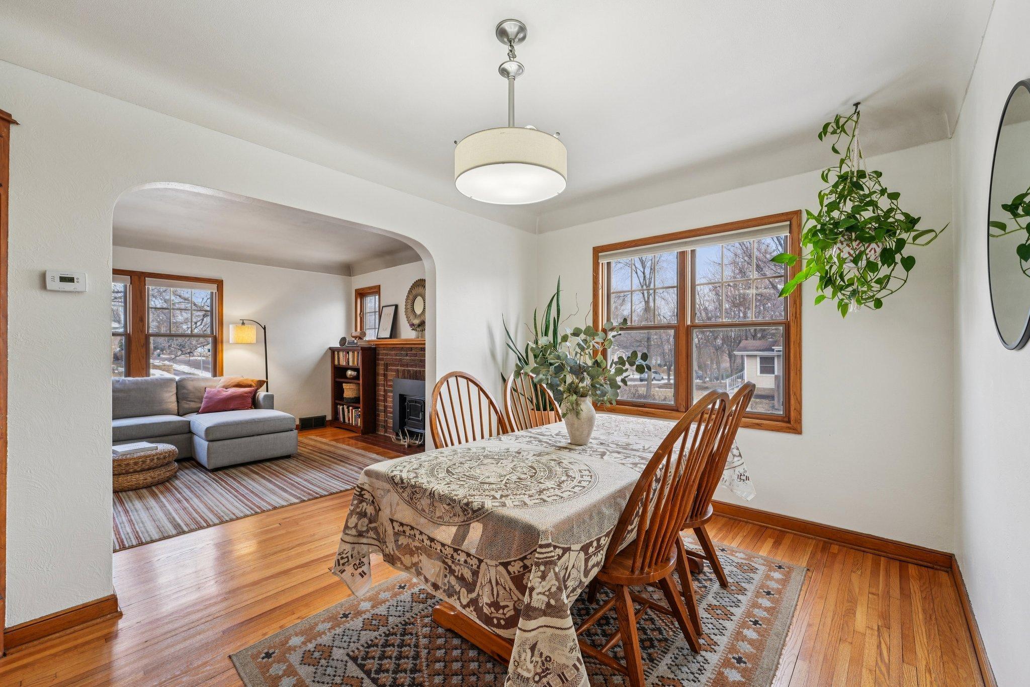 Sun filled dining room with hardwood floors and arched opening connecting seamlessly to the living space.