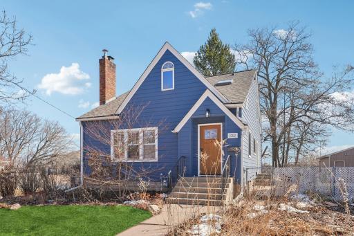 Charming bungalow with welcoming entry, updated siding, mature trees, and established perennial gardens on a fully fenced lot.