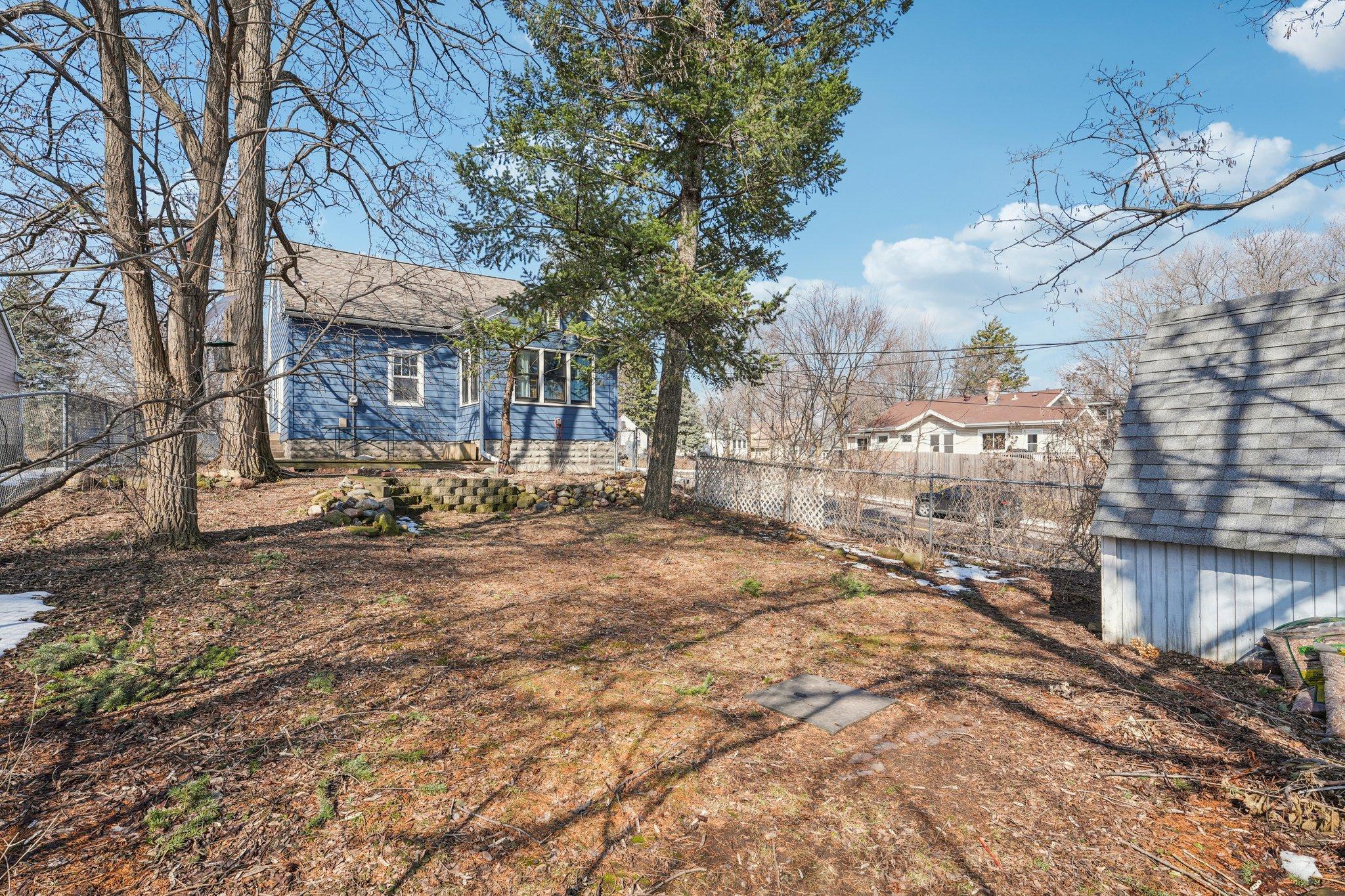 Large fully fenced backyard with mature trees, privacy, and space for gardens, play, or entertaining.