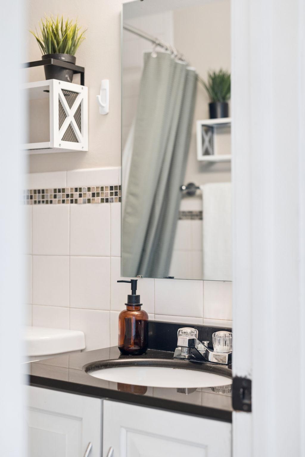 Stylish main level full bathroom with sleek tile accents.