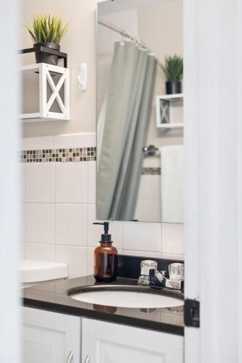 Stylish main level full bathroom with sleek tile accents.