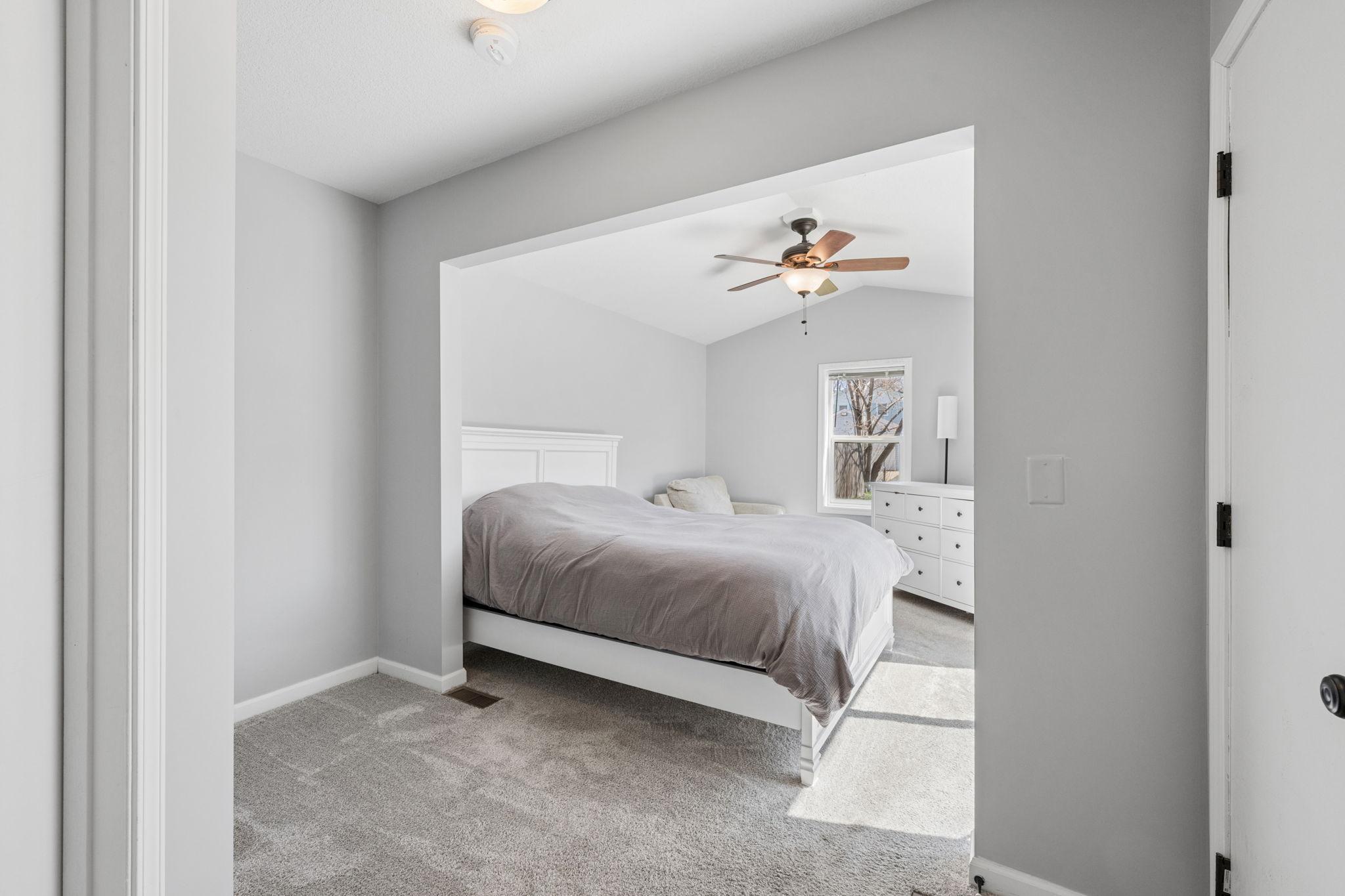 The spacious primary bedroom with a vaulted ceiling is a true retreat.