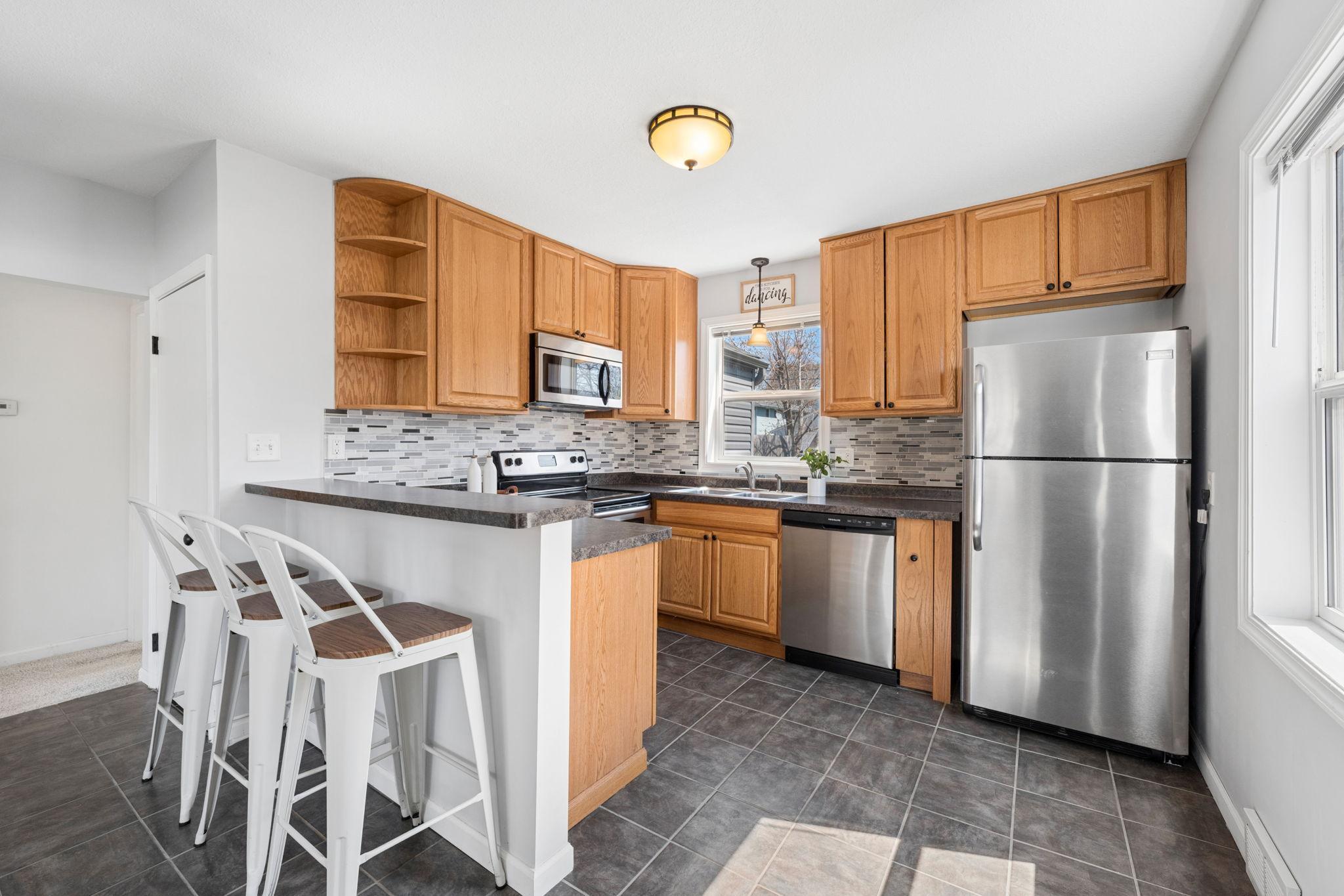 Ample storage space, stainless steel appliances, and modern tile backsplash make this kitchen a chef's dream.