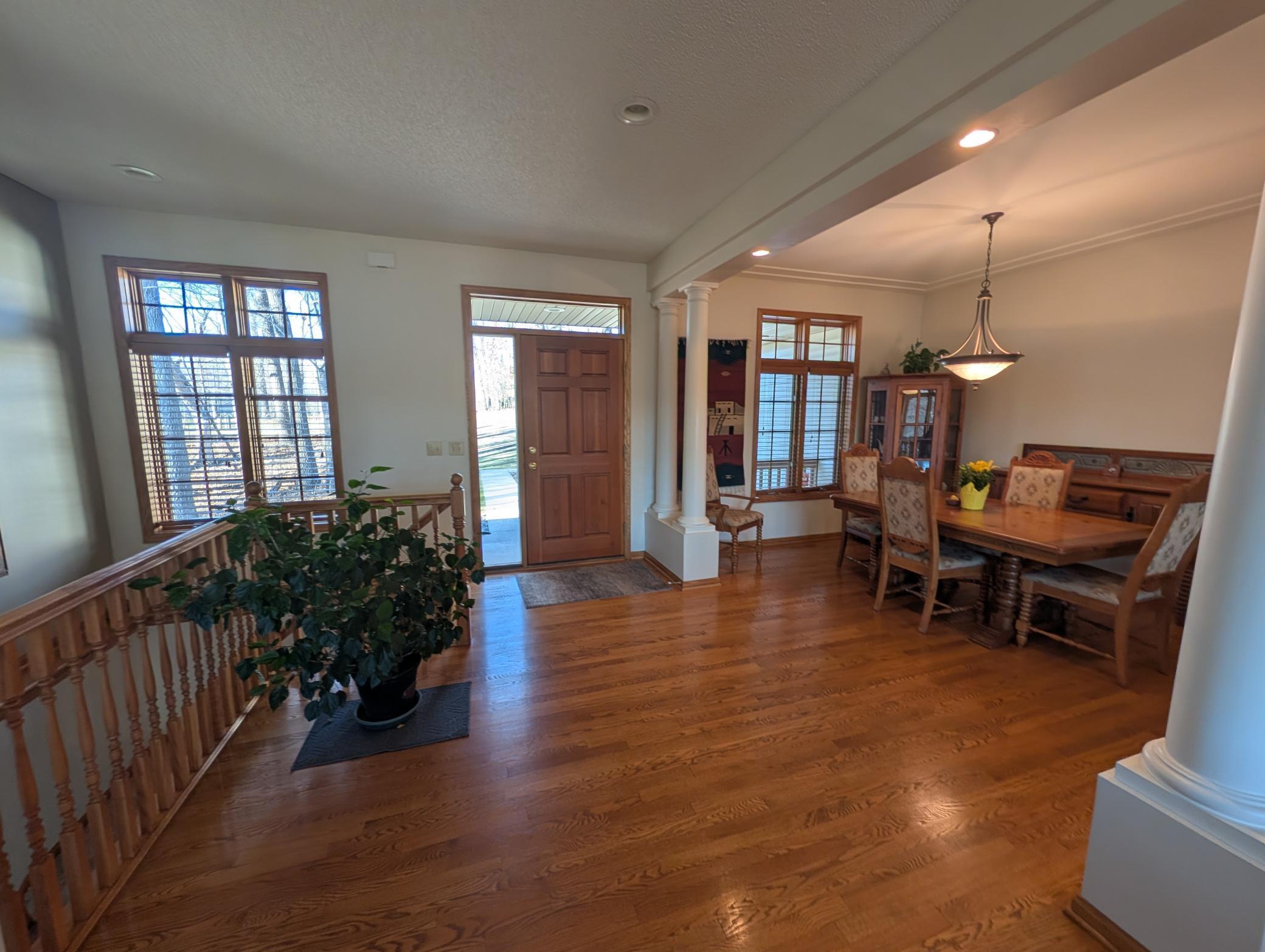 Front door with large entry and formal dining room with beautiful wood floors