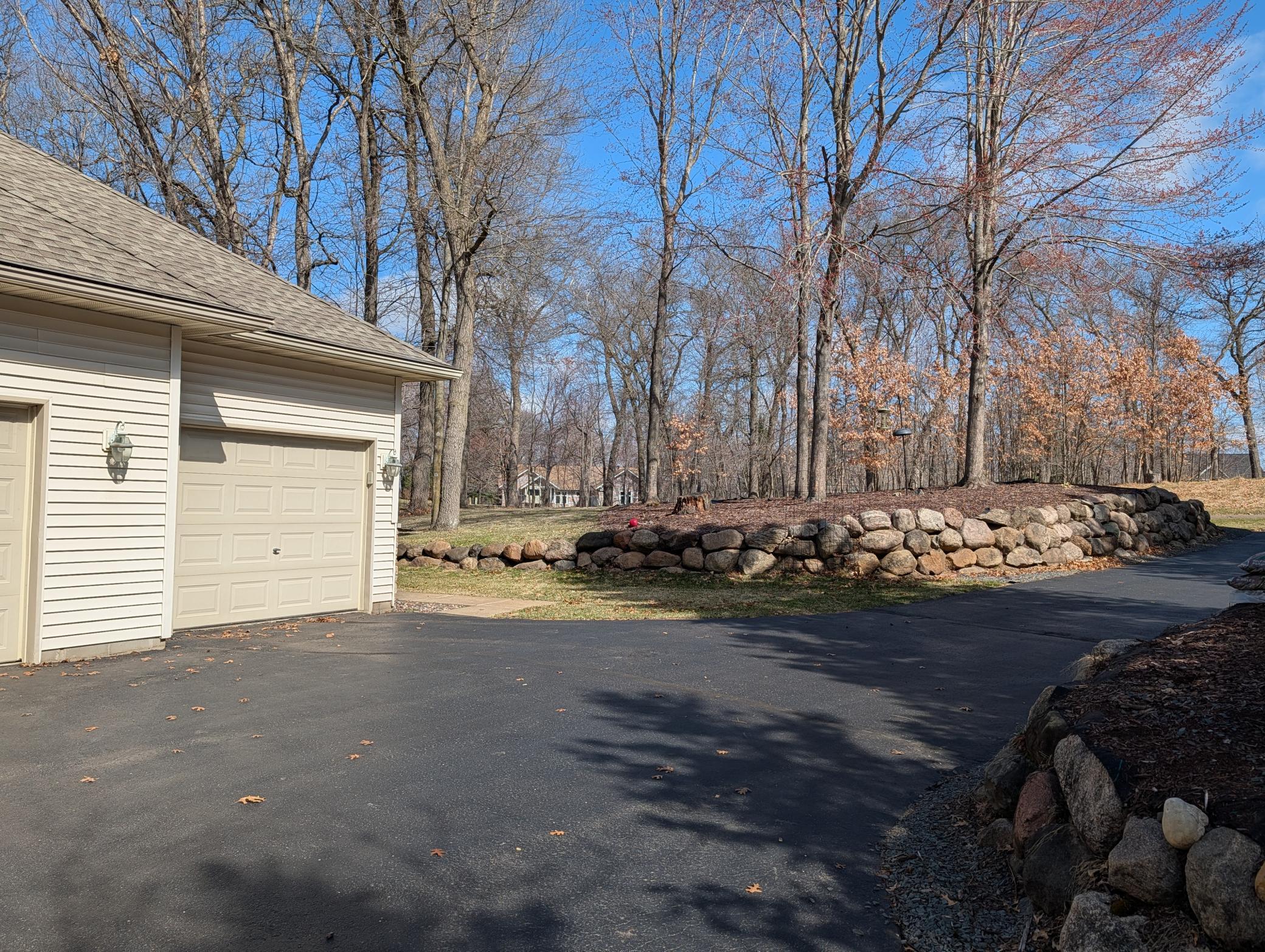 Entrance to home with boulder walls on either side of the driveway